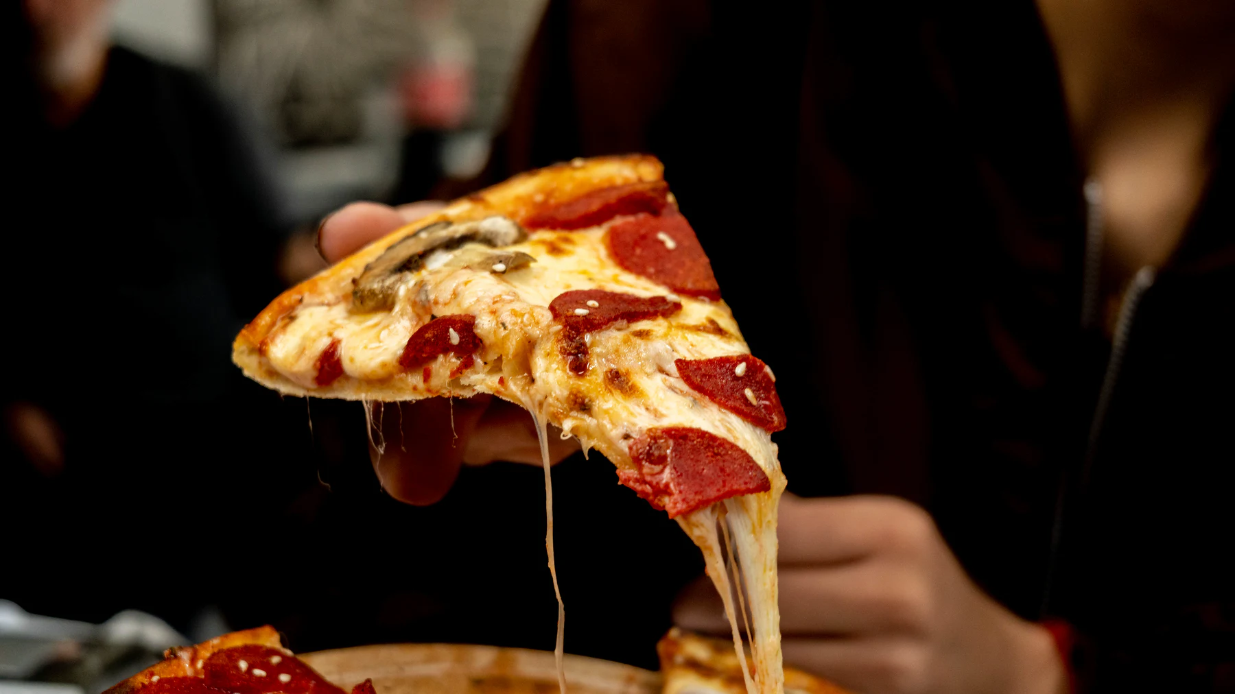 Bol malzemeli bir pizza diliminin yakın çekimi.
